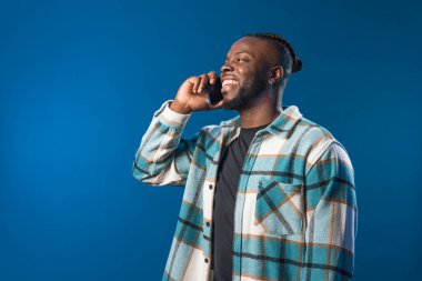 Yakışıklı siyah adam telefonda konuşuyor mutlu ve gülümsüyor..