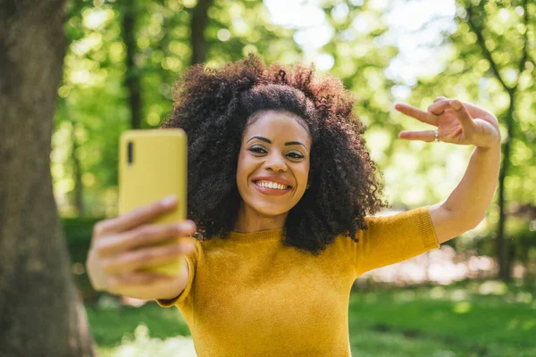 Menina afro bonita tirando uma selfie rindo. — Fotografia de Stock