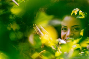 Yaprakların arasından güzel bir afro kadın portresi..
