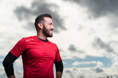 Sportif adam mutlu görünüyor ve gülümsüyor..