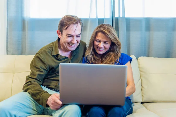 Uśmiechnięty dojrzały mężczyzna i kobieta rozmawiający przez wideo połączenie z laptopem — Zdjęcie stockowe