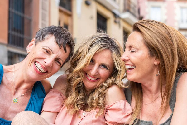 Drei lachende reife Freunde blicken gemeinsam in die Kamera — Stockfoto