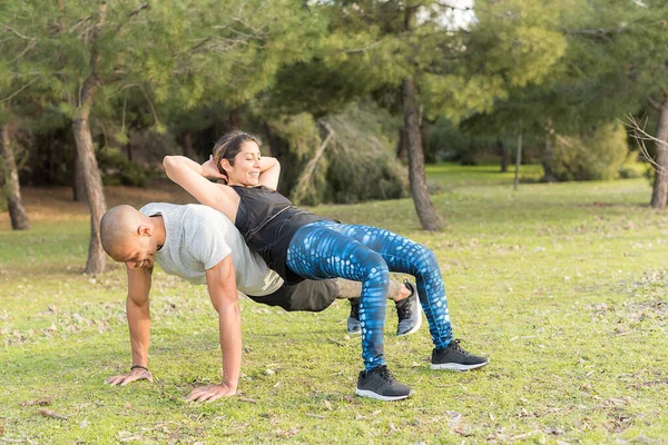 Pareja de fitness haciendo ejercicio de levantamiento espalda a espalda en el parque — Foto de Stock