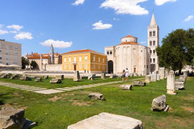 Zadar Roma Forumu, St. Donatus Kilisesi ve mavi gökyüzünün altındaki çan kulesiyle harabeleri turistlerin ilgisini çekiyor.