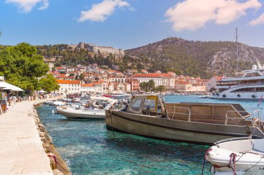 Hvar kasabası limanı, demirli tekneleri ve güneşli bir yaz gününde tarihi Fortica kalesini gösteriyor.