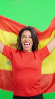 İspanyol bayrağını yeşil ekranda tutarak zaferi kutlayan kendinden geçmiş kadın spor hayranı.