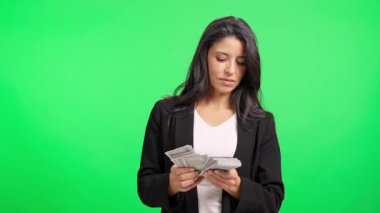 Mutlu iş kadını yeşil ekran arka planında yığınla para sayıyor, başarı kavramı.