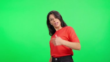 Kafkas bir kadın meydan okuyucu bir tavırla yeşil bir arka plana yaklaşmaya çalışıyor.