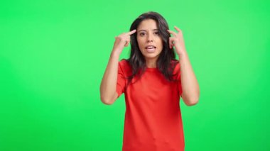 Sinirli ve hayal kırıklığına uğramış bir kadın yeşil arka planda konuşurken öfkesini ve hayal kırıklığını ifade ediyor.