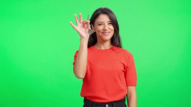 Gülümseyen kadın yeni evinin anahtarlarını gururla sergiliyor.