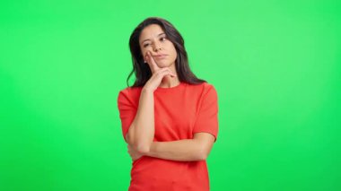 İlgisiz beyaz kadın, krom bir arka planda durmaktan sıkılmış ve yorgun hissediyor.