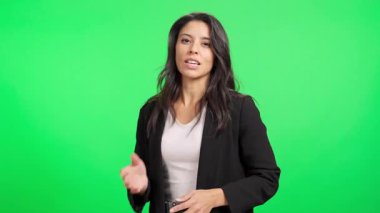 Profesyonel Latin kadın bir konsepti anlatırken kroma tuşuna karşı jestler kullanıyor.