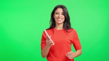 Krom anahtar arka planında kameraya yeşil ekranlı cep telefonu gösteren güzel bir kadın.