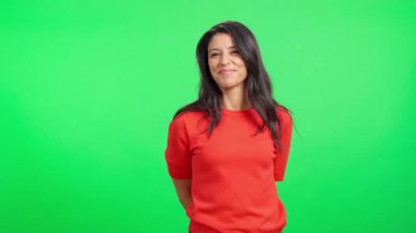 Gülümseyen Latin kadın, krom anahtar arka planında kameraya küçük bir hediye kutusu sunuyor.