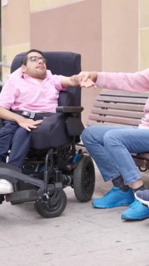 Fiziksel engelli mutlu arkadaşlar şehrin sokaklarında birlikte vakit geçiriyorlar.