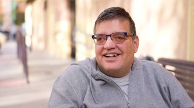 Fiziksel engelli bir adam gülümsüyor ve başka tarafa bakıyor. Kapsamlı bir anın tadını çıkarıyor.