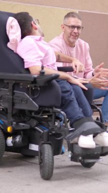 Fiziksel engelli insanlar tekerlekli sandalyede oturup dışarıda sohbet etmekten zevk alırlar.