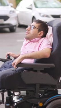 Elektrikli sandalyesinde oturan fiziksel engelli bir adam.