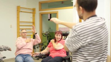 Çeşitli fiziksel engelleri olan bir grup insan rehabilitasyon terapisine katılıyor.