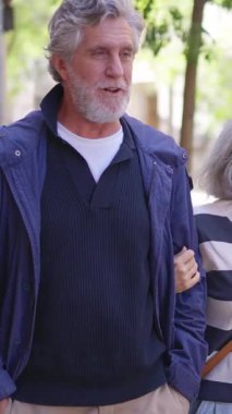 Bir grup şık olgun arkadaş sokakta gülerek ve konuşarak yürüyüş yapıyorlar.