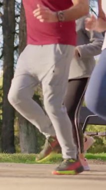 Bir grup aktif yaşlı insan parkta birlikte koşuyor sağlıklı ve formda bir yaşam tarzının keyfini çıkarıyorlar.