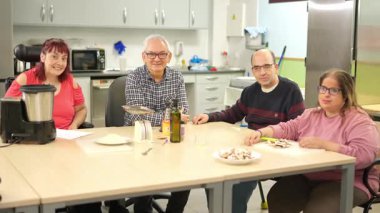 Fiziksel engelli insanlar yemek atölyesi sırasında birlikte gülümseyip öğreniyorlar.