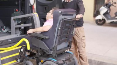 Tekerlekli sandalyedeki adam ulaşılabilir bir araç kullanıyor.