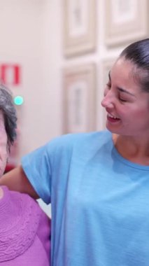 Sevecen bir torun. Yaşlı büyükannesiyle yavaş çekim sahnesinde kucaklaşıp konuşuyor.