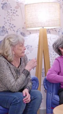 Genç bir kadın huzurevindeki yaşlı büyükannesini ziyaret ediyor, onunla ve başka bir sakinle konuşuyor.