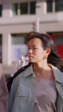 Güneşli bir günde genç ve çok ırklı bir çift şehirde birlikte yürüyor.