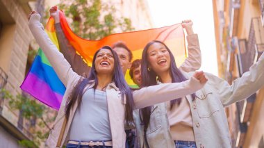 Çeşitli gençler gökkuşağı bayrağıyla kapsama ve çeşitliliği kutluyorlar.