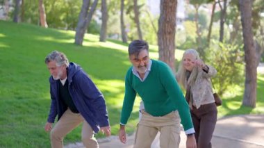 Mutlu çiftler birlikte eğlenirken erkekler parktaki eşlerine sırt sırta biniyor.