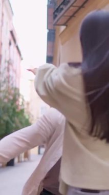 Bir kadına doğru koşan mutlu bir adam, şehirde ona duygusal ve sıcak bir şekilde sarılıyor.