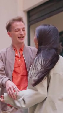 Birbirine gülümseyen ve sarılan iki çok ırklı arkadaşın yavaş çekim videosu.