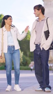 Mutlu heteroseksüel çift şehir parkında birlikte dikilirken sohbetin tadını çıkarıyor.