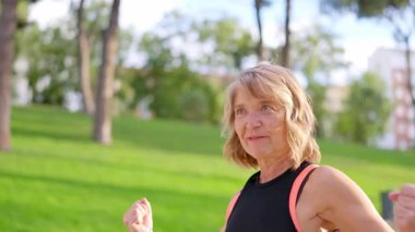 Gri saçlı neşeli olgun kadın gülüyor, mutluluğunu ifade ediyor ve aktif bir yaşam tarzının tadını çıkarıyor.