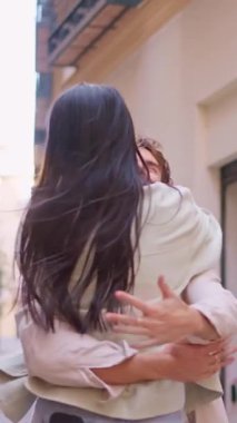 Bir grup beyaz arkadaş birbirine doğru koşuyor. Dar bir sokakta buluşup sarılıyorlar.