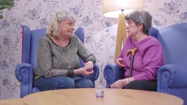 İki kıdemli bayan arkadaş bir huzurevinde oturmuş sohbet ediyorlar.