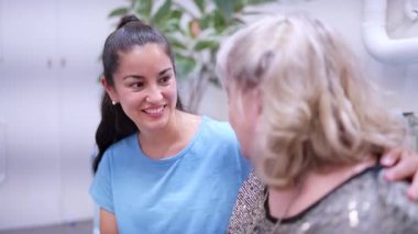 Genç bir kadın gülümsüyor ve bir konuşma sırasında büyükannesini şefkatle dinliyor.