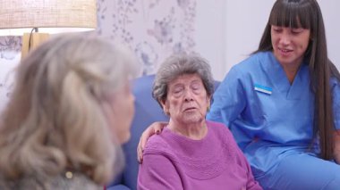Genç hemşire, huzurevindeki yaşlı bir asistana duygusal destek ve bakım sağlıyor.