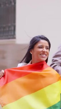 lgbtqia 'yı kutlarken gülümseyen mutlu lezbiyen kız artı gökkuşağı bayrağı tutan gururlu ay