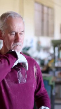 Ahşap atölyesinde çalışmaya başlamadan önce koruyucu gözlük ve eldiven takan olgun bir marangoz.