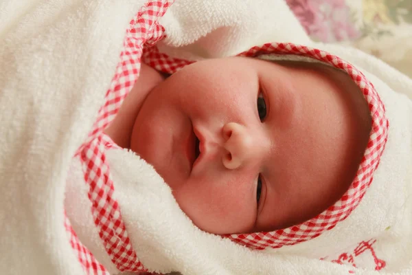 女の赤ちゃんは白い毛布に隠れています。 — ストック写真