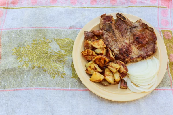 Свиной стейк картофель в деревне белый лук — стоковое фото
