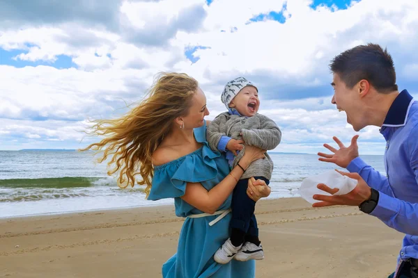 Pai e mãe brincando com o jovem filho na praia — Fotografia de Stock