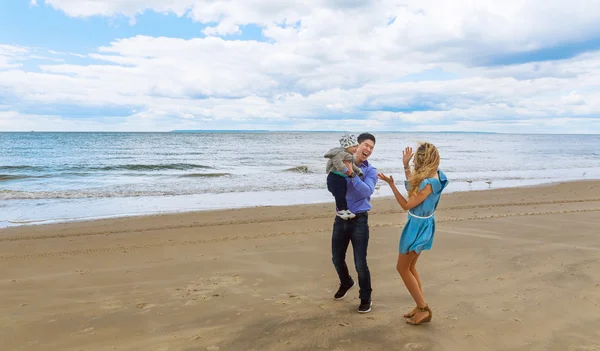 Padres jugando con su hijo en la playa — Foto de Stock