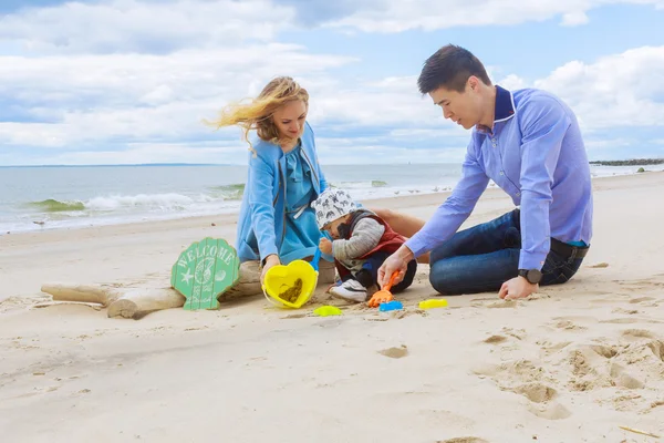 Pais brincando com seu filho na praia — Fotografia de Stock