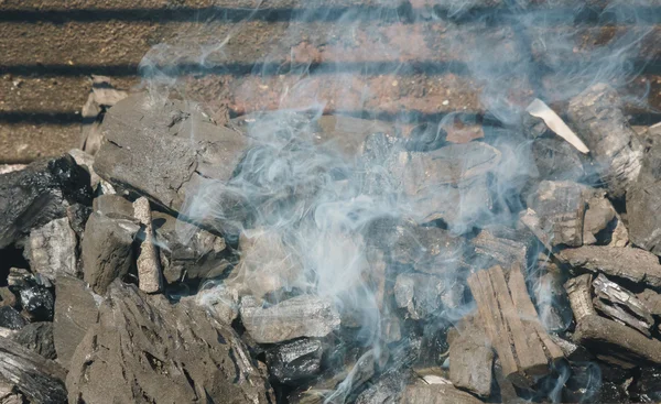 Charbons lumineux dans un barbecue fumée de feu de charbon — Photo