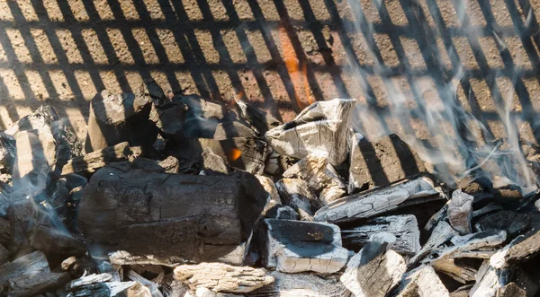 Charbons lumineux dans un barbecue fumée de feu de charbon — Photo