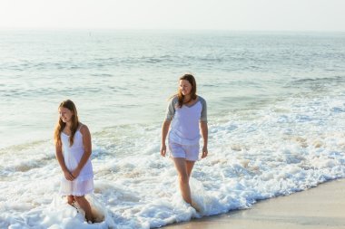 Aile akşam sahilde günbatımı sırasında yürüyüş.